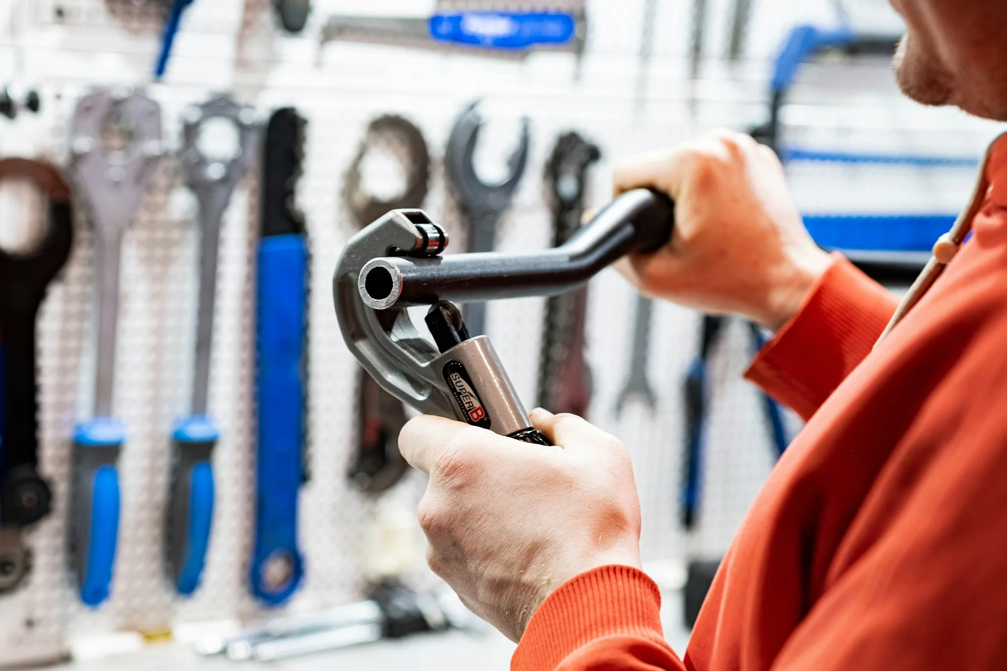 Technician selecting a tool from a workshop pegboard