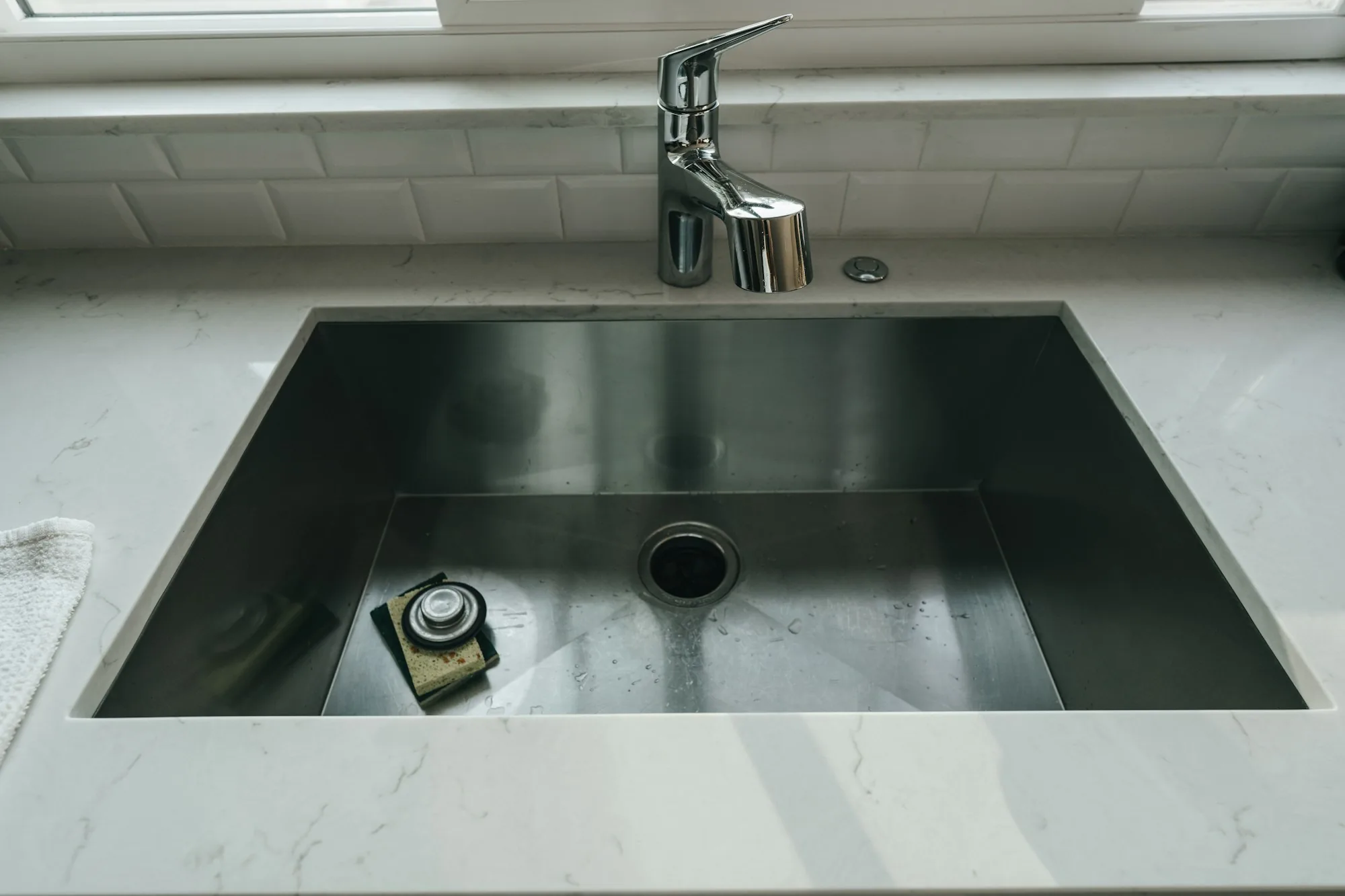 Deep stainless sink basin set into a stone counter