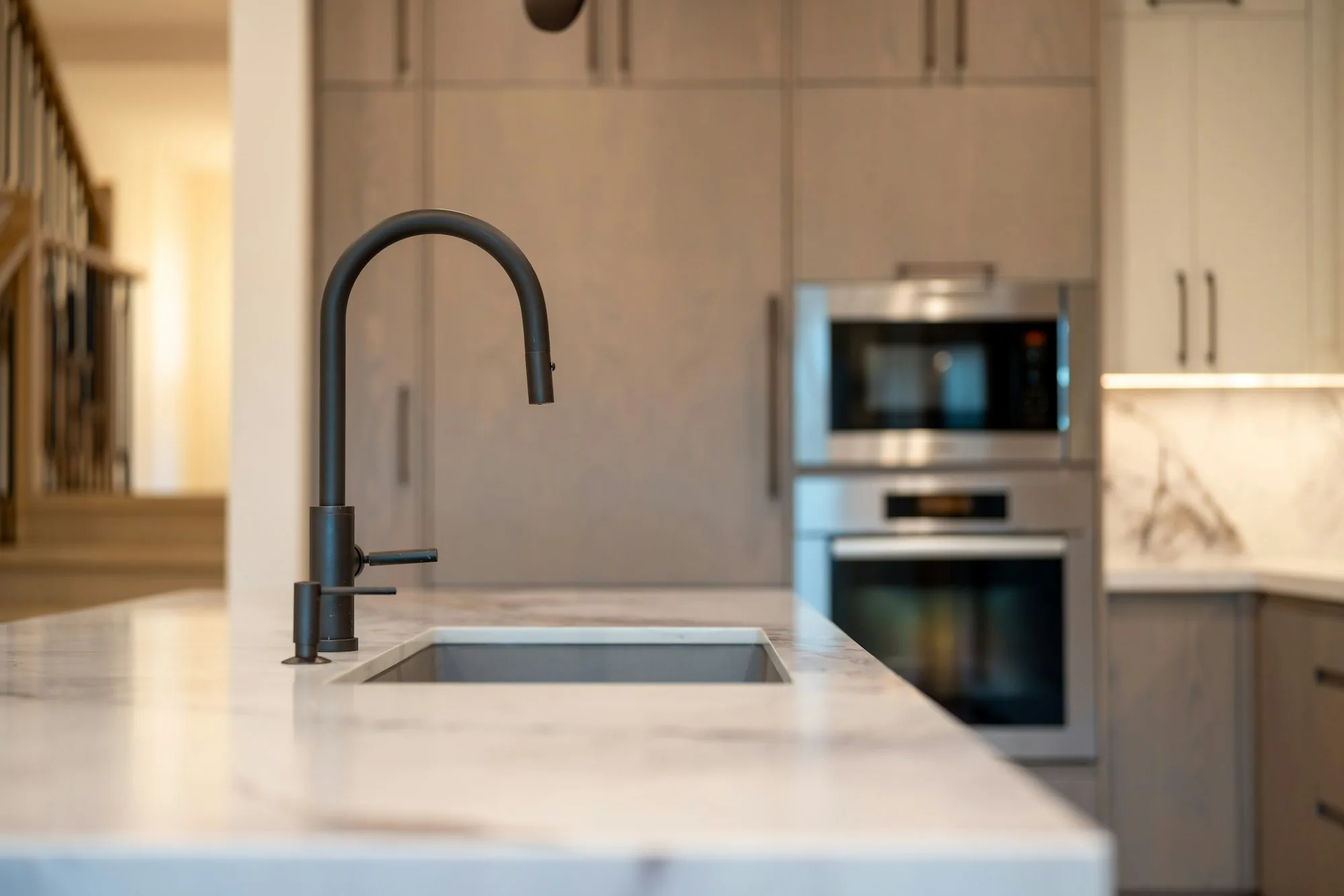 Matte black faucet over a stone counter in a modern kitchen