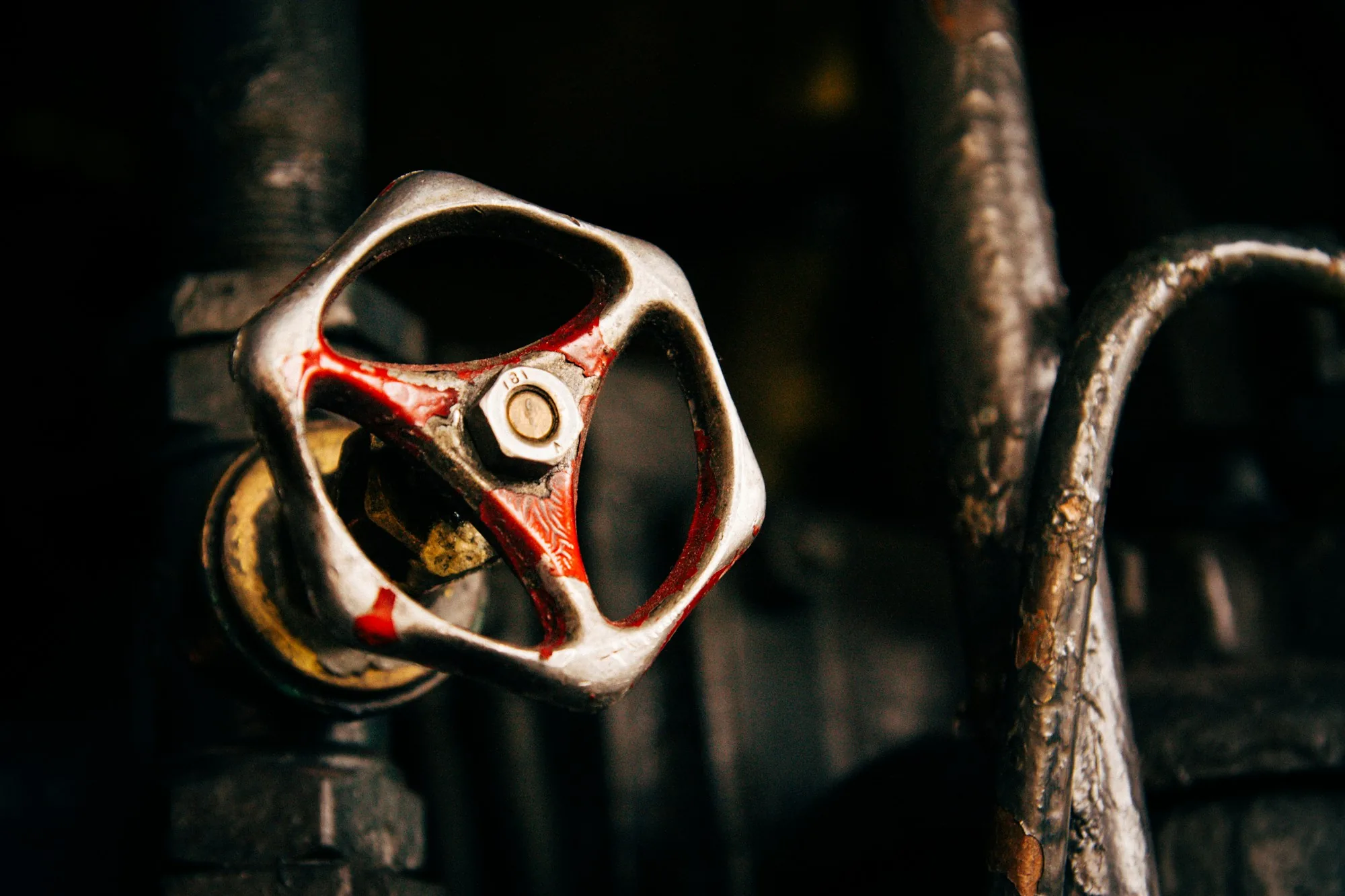Rusted red valve wheel on old pipework