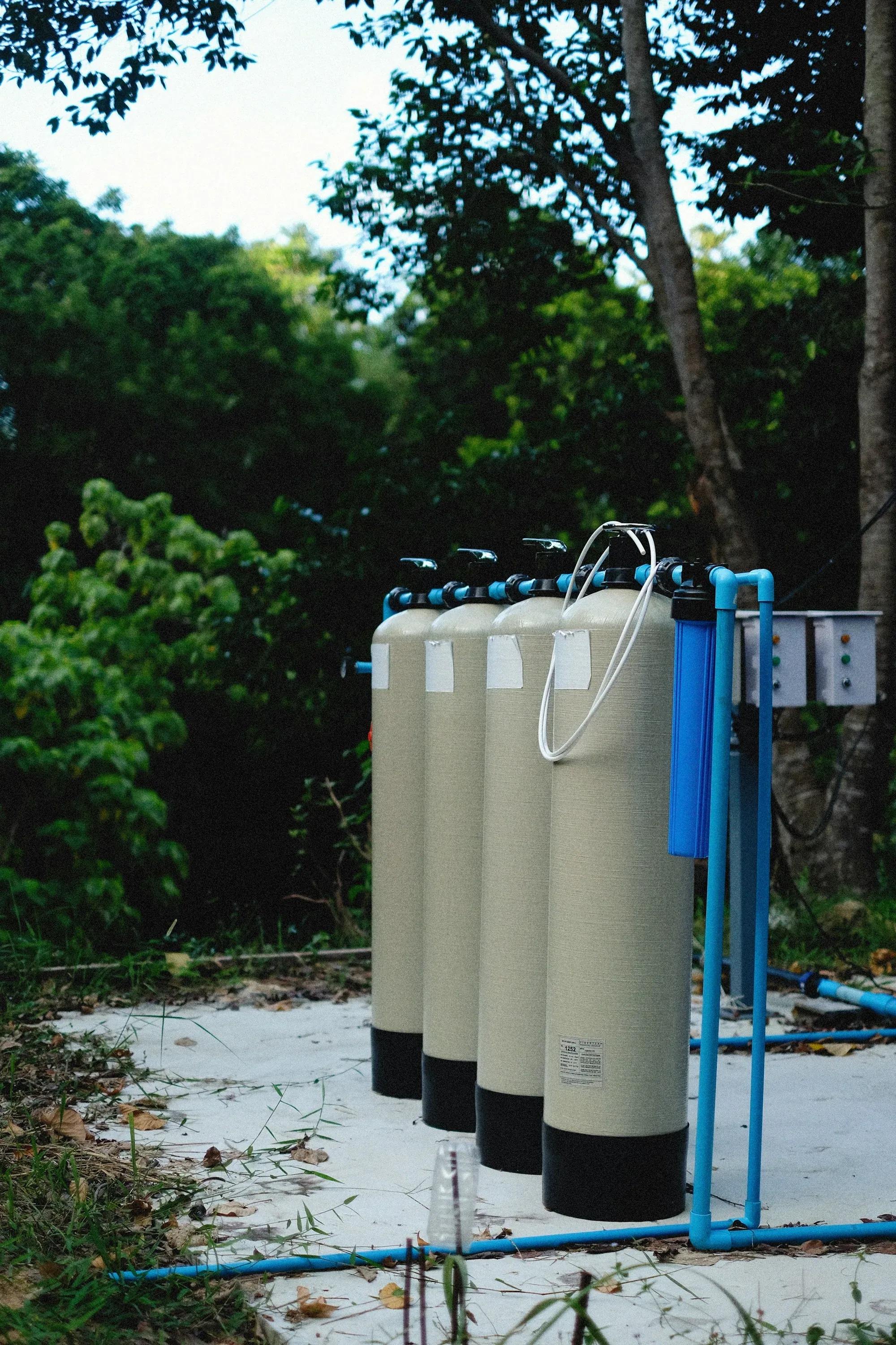 Bank of whole-house filter vessels plumbed outside a property